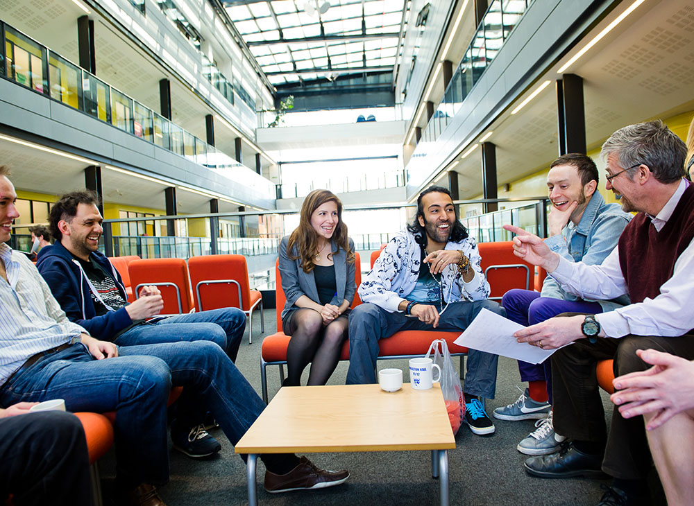 A group of students and professor having a conversation.