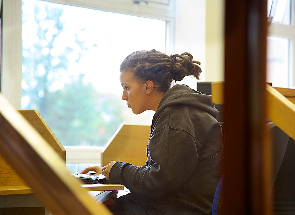 Student looking at screen with hand on keyboard.