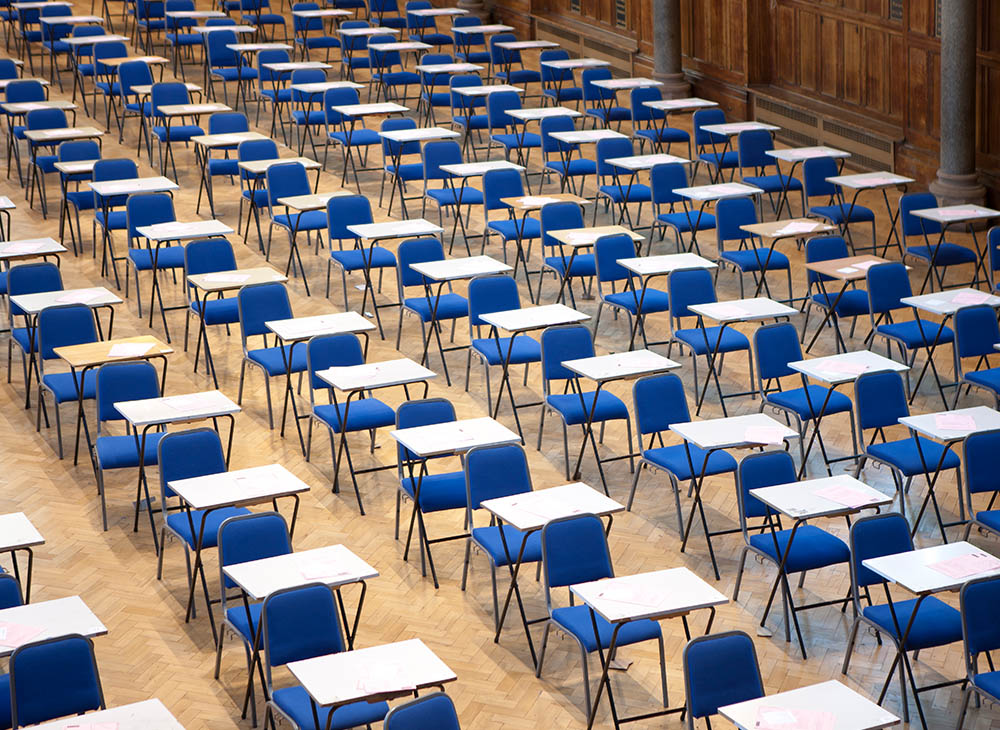 Empty exam hall full of chairs and desks.