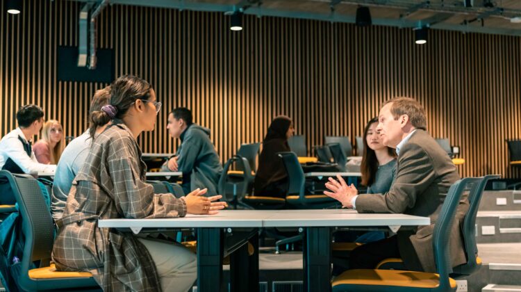 Professor Peter Green meeting and chatting with students in the Nancy Rothwell building.