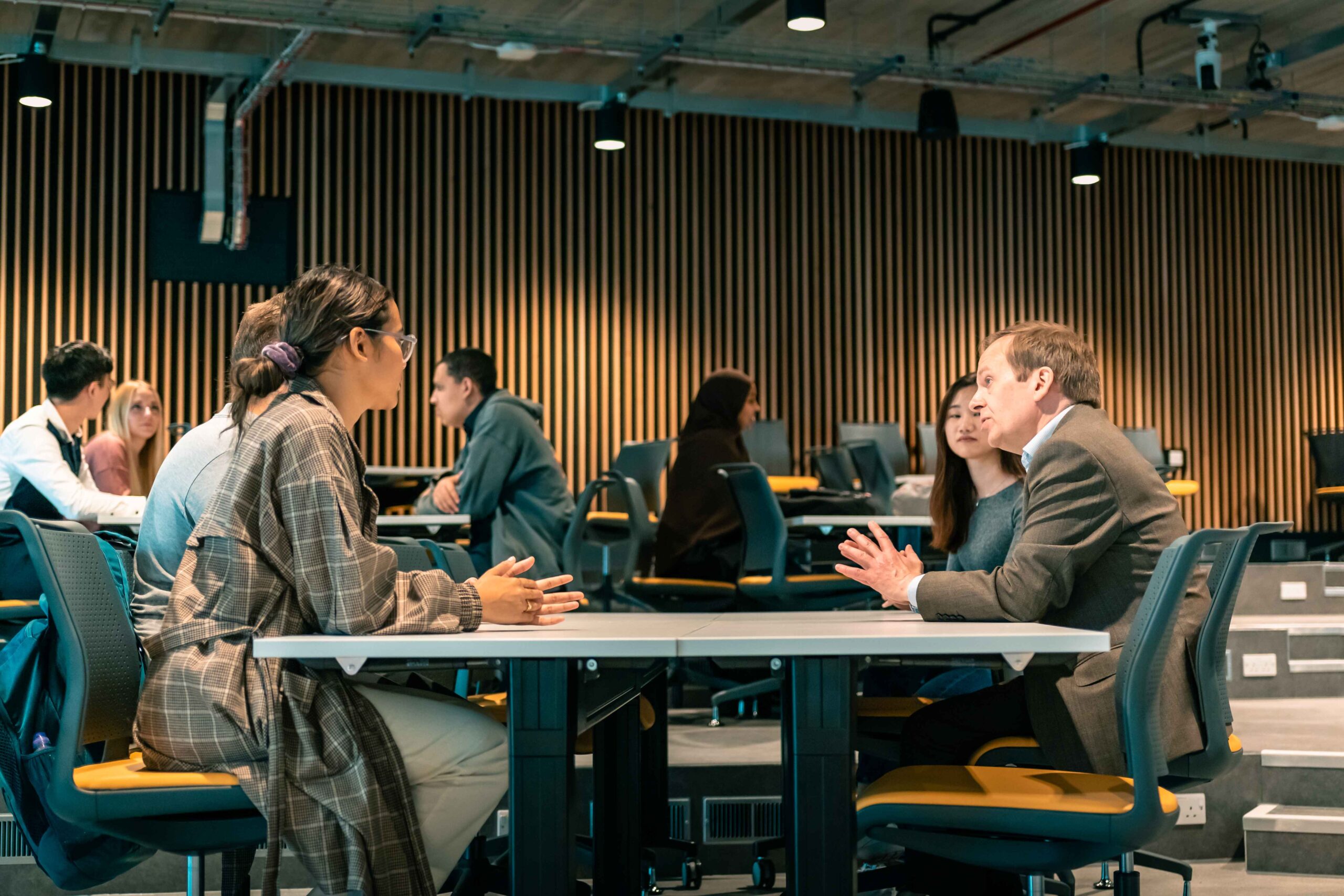 Professor Peter Green meeting and chatting with students in the Nancy Rothwell building.