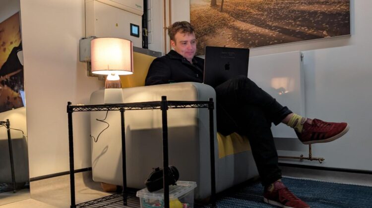 A person sat in a comfortable armchair in low lighting.